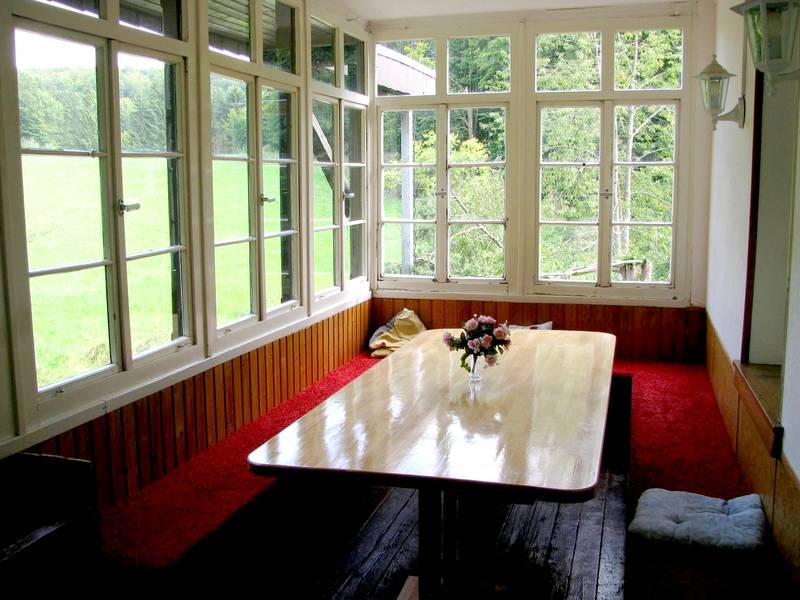 Holzveranda mit Blick auf die Wiese.